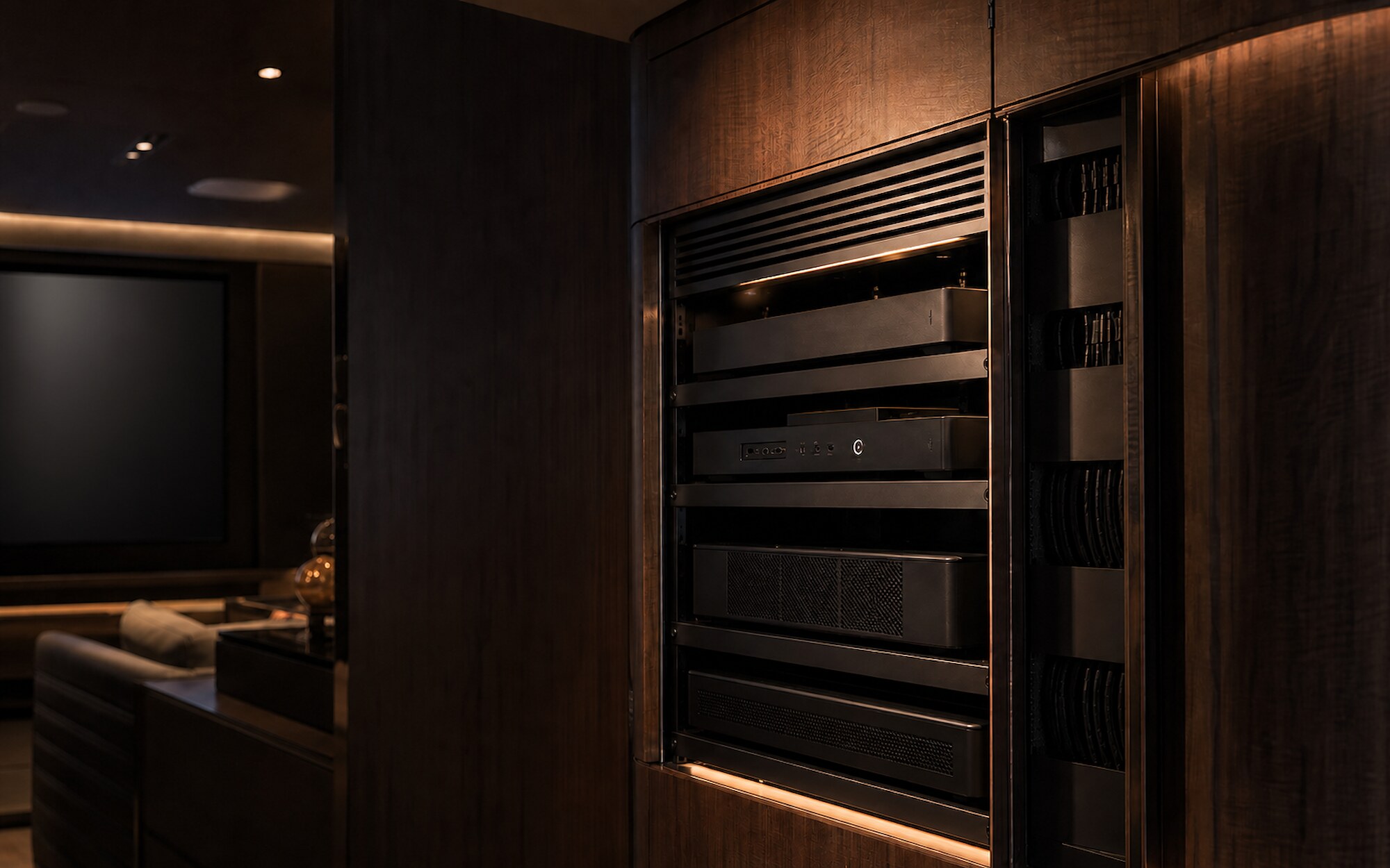 Conceptual home cinema equipment integrated into dark timber joinery with dressed cabling and restrained warm lighting.